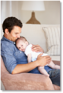 Man Holding His Infant Child on a Couch