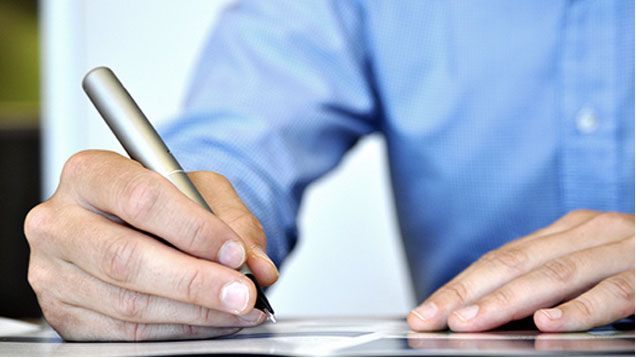 Close Up of a Man's Hand Signing a form with a Pen